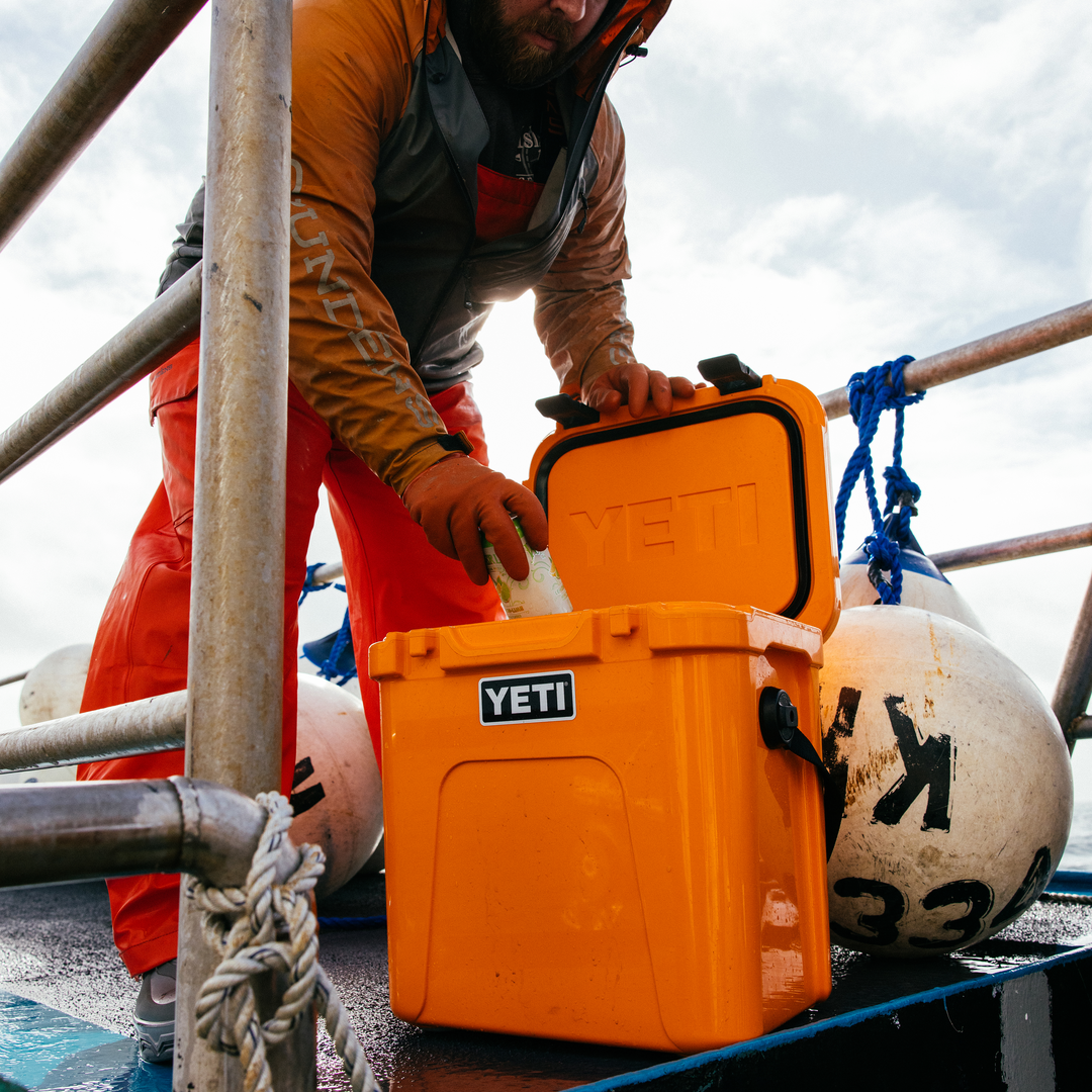 Fischer trägt eine YETI Roadie Kühlbox in King Crab Orange